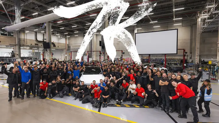 Giga Berlin team on the factory floor around a Model Y under a big “7K”