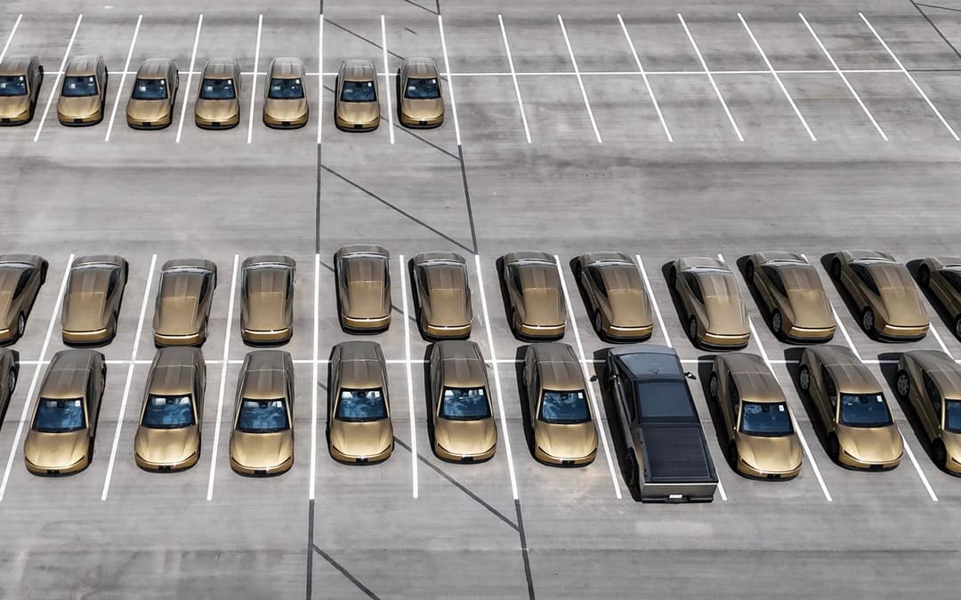 Aerial view of one dark Cybertruck parked among rows of gold Cybercabs (“Guardian of the fleet”)