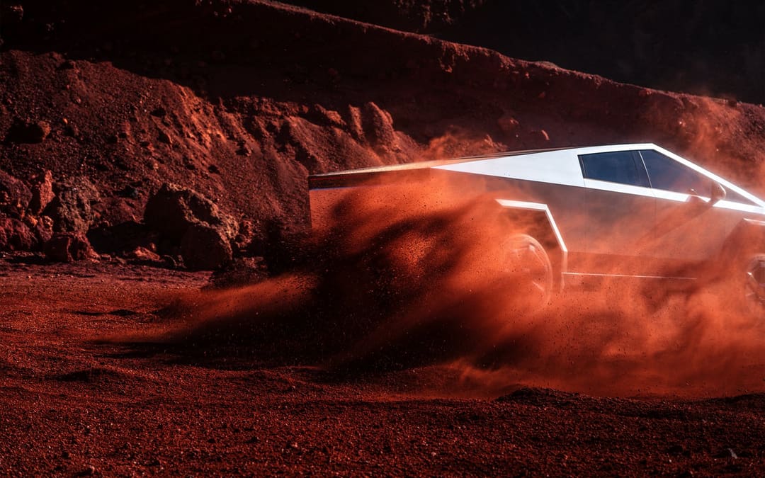 Cybertruck kicking up red dust on a desert trail